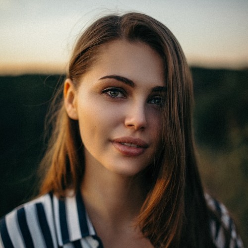 Portrait of a woman with long cocoa hair in natural light.