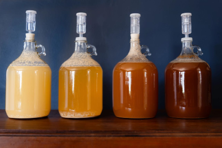 4 gallons of mead, each of different color, mid brewing process